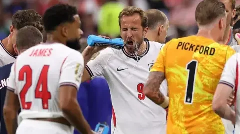 Getty Images Harry Kane squirts water on his face during a hydration break in England's match against Croatia at the 2026 World Cup.